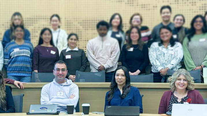 Group of participants in a classroom setting with laptops, attending a tech workshop.